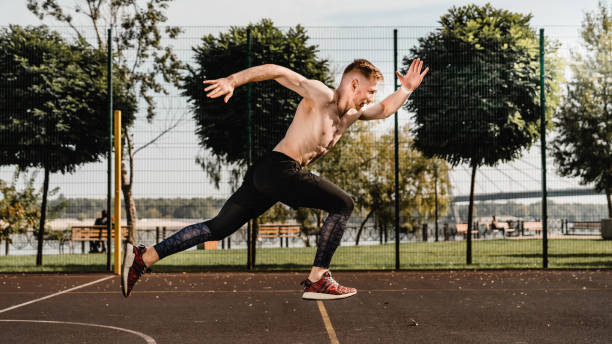 istock Young slim male runner jogging on sporting ground 1292749946