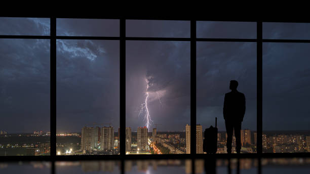 istock The man with a suitcase standing near the panoramic window against the thunder 1292751122