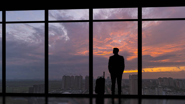 istock The man with a suitcase standing near the panoramic window 1292751141