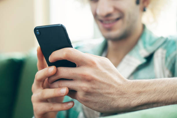 istock Young man on a couch at home, using mobile phone 1292751425