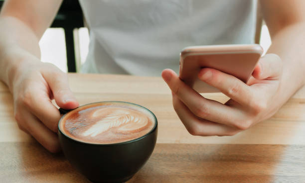 istock white mobile phone Mockup image   man  hands holding   with blank screen for your advertising 
 
mobile phone during coffee break in cafe 1292753265