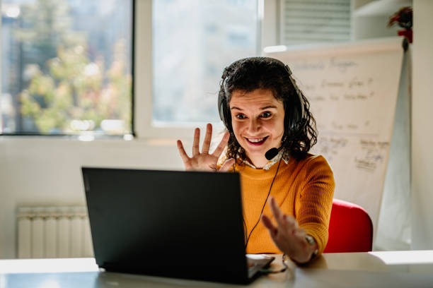 istock Teacher using a laptop and headphones teaching from home 1292753415