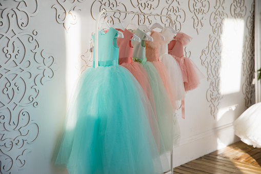 Hanger with colorful elegant puffy dresses for girls. holiday wardrobe. showroom of holiday clothing for children.