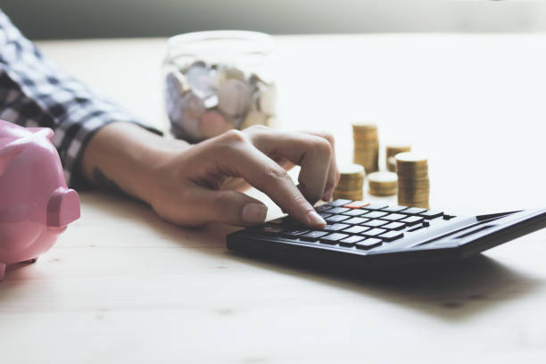 istock Financial data analyzing hand writing and counting on calculator in office on wood desk 1292753792