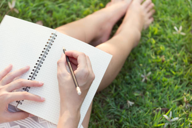 istock relax girls hands with pen writing on notebook in park 1292754238