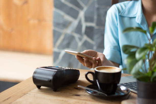 istock cafe making show transfer payment through smartphone app Mobile Payment with NFC technology on Smartphone shopping online 1292754318