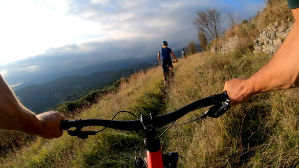 istock Mountain bikers ride through grassy meadow in the morning 1292754388
