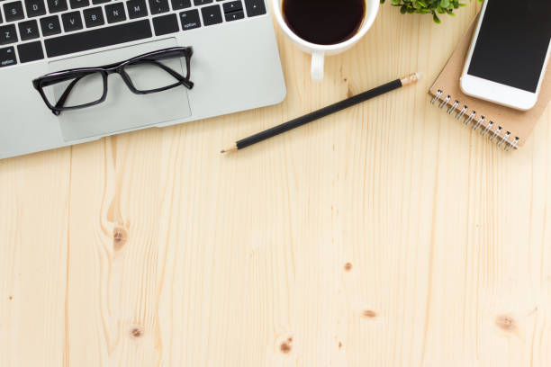 istock wood office desk table with computer, office supplies. and coffee cup. Top view with copy space flat lay. 1292754429