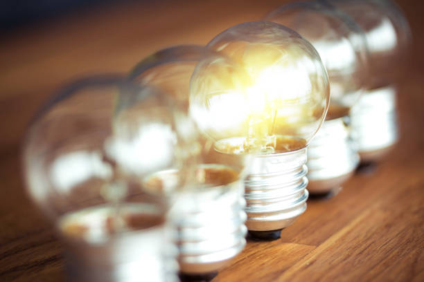 istock glowing bulb uniqueness concept on brown wooden table 1292755229