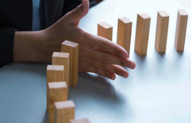 istock businessman hand stop dominoes continuous toppled or risk with copyspace 1292755280