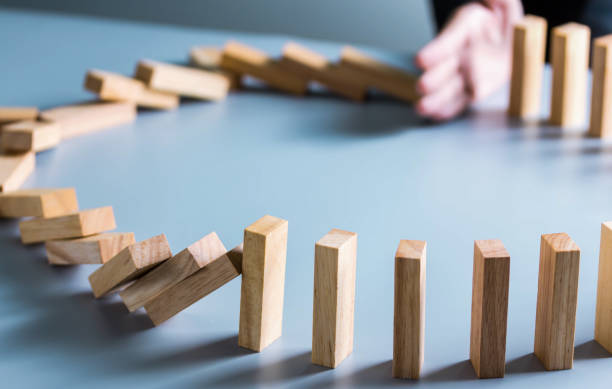 istock Businessman hand stop dominoes continuous toppled or risk with copyspace. Business risk, strategy and planing concept idea. 1292755296