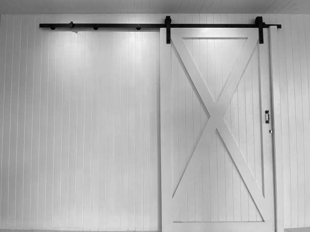 istock Large white sliding doors and black sliding rails against white walls. 1292756637
