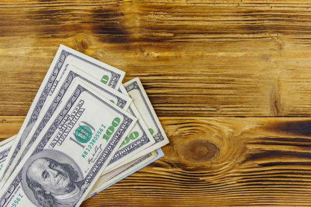 istock Stack of one hundred dollars bills on wooden desk 1292756856