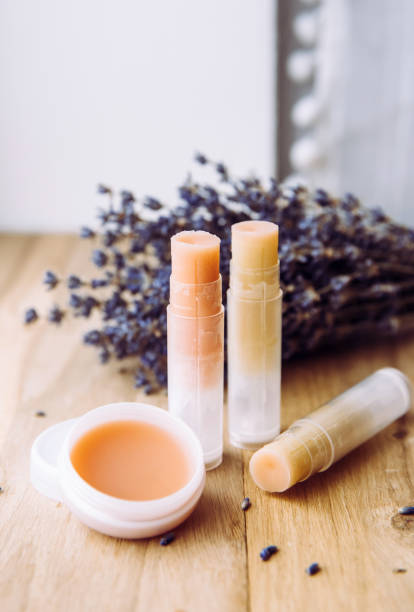 faire maison des ingrédients biologiques naturels baume pour les lèvres. baume à lèvres fait main et rouge à lèvres à l’intérieur du récipient sur fond en bois naturel et lavande pour la décoration. - lip balm photos et images de collection