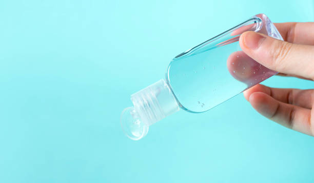 istock hand use bottle alcohol clean with hand sanitiser liquid bottle . concenpt protection sanitiser tool protect corona virus on  turqouise isolated background 1292759186