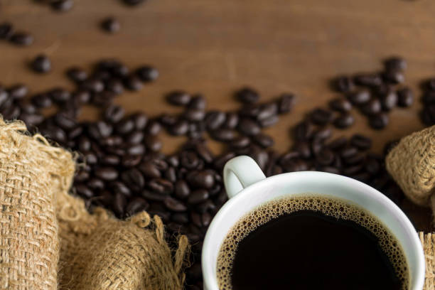 istock Hot Coffee cup with Coffee beans on the wooden table 1292760138