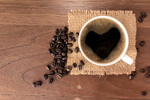 istock Hot Coffee cup with Coffee beans on the wooden table 1292760163
