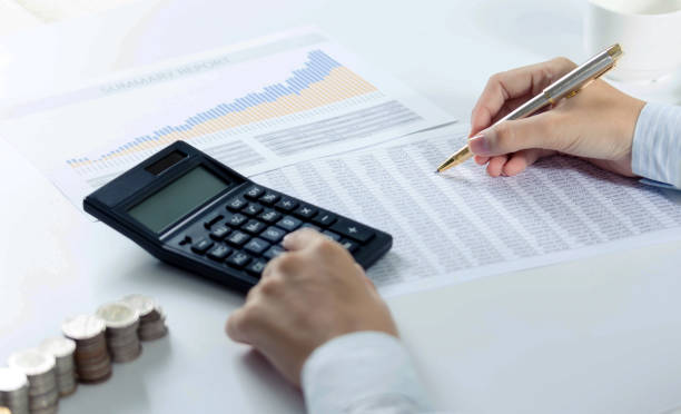 istock Woman using calculator with doing finance at home office. 1292761058