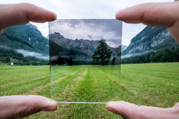 istock Professional photographer holding ND Gradient Filter glass appreciating an effect. Logar valley, Slovenia. 1292762018