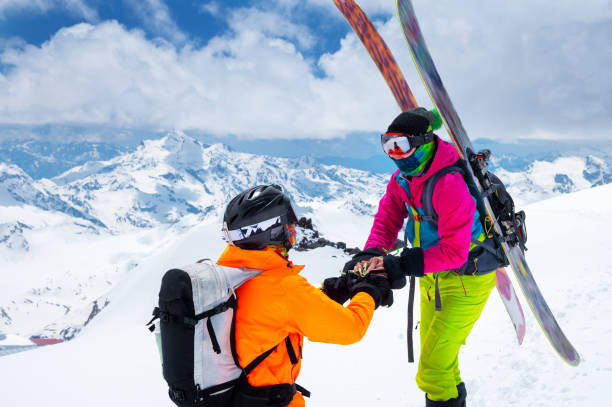 A man athlete skier freerider makes a proposal to marry his woman skier high in the mountains in winter. against the backdrop of snow-capped peaks. Wedding proposal in extreme conditions A man athlete skier freerider makes a proposal to marry his woman skier high in the mountains in winter against the backdrop of snow-capped peaks. Wedding proposal in extreme conditions. unusual couple stock pictures, royalty-free photos & images