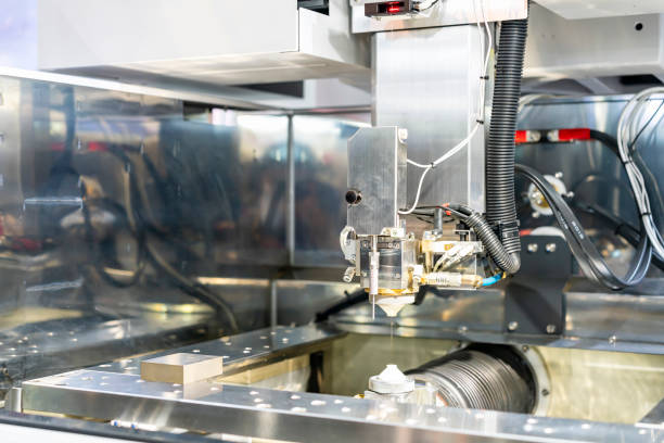 istock Close up nozzle and wire guide control feed unit of high technology and precision cnc edm electric wire cut machine for metal forming in manufacturing process at factory 1292769557