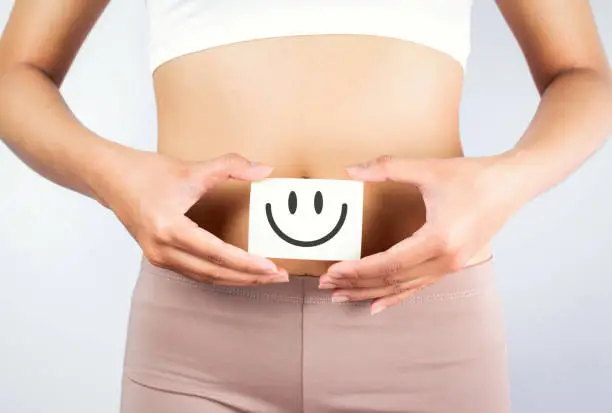 Photo of Women Stomach Health. Healthy Female With Beautiful Fit Slim Body  Holding White Card With Happy 
Smiley Face In Hands Good Digestion Concepts. High Resolution