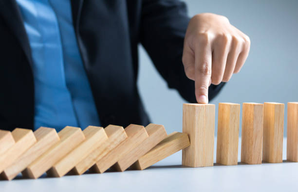 istock businessman hand stop dominoes continuous toppled or risk 1292771205