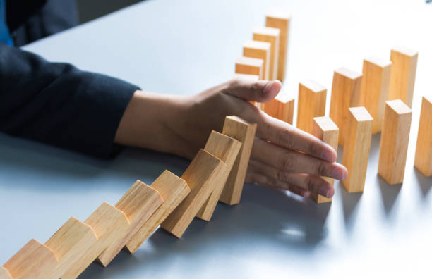 istock businessman hand stop dominoes continuous toppled or risk with copyspace 1292771211