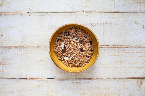 Overhead view of a bowl of dry granola - a rustic setting