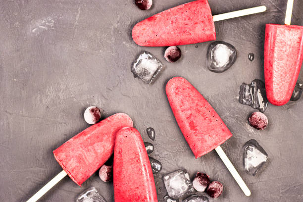 istock frozen red ice cream on a stick with chunks of ice on a black background. 1292773574