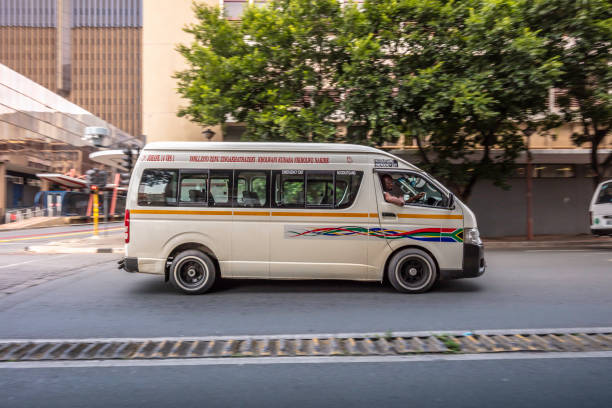 Taxi driving through the city of Johannesburg Taxi driving through the city of Johannesburg, mini buses are used as a taxi business throughout south africa. johannesburg photos stock pictures, royalty-free photos & images