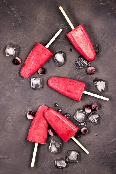 istock frozen red ice cream on a stick with chunks of ice on a black background. 1292774792