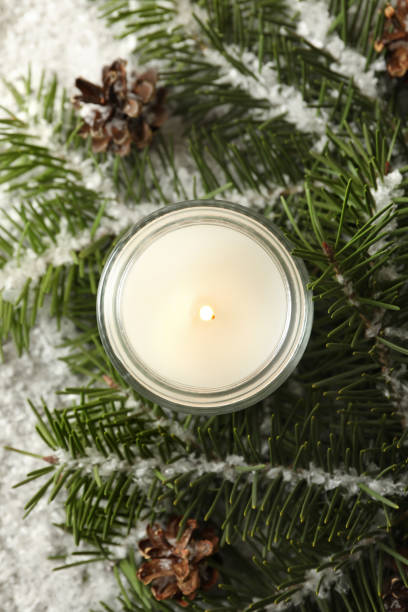 istock Scented candle, pine branches and snow, top view 1292775700