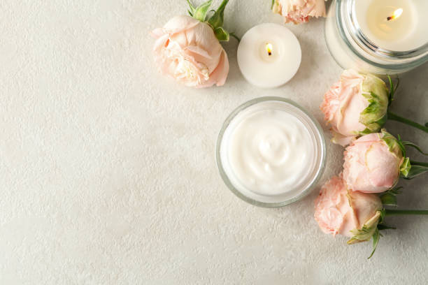istock Scented candles, cosmetic cream and roses on white table 1292775732