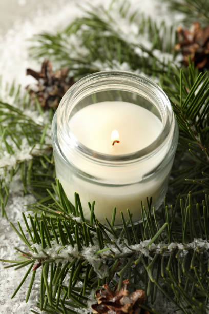 istock Scented candle, pine branches and snow, close up 1292775884