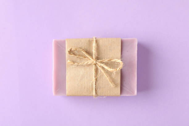 istock Piece of natural soap on violet background 1292776175