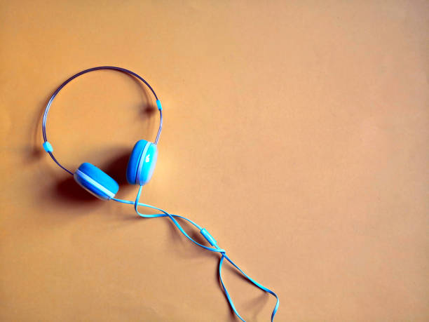 istock Blue headphones on orange background 1292776810
