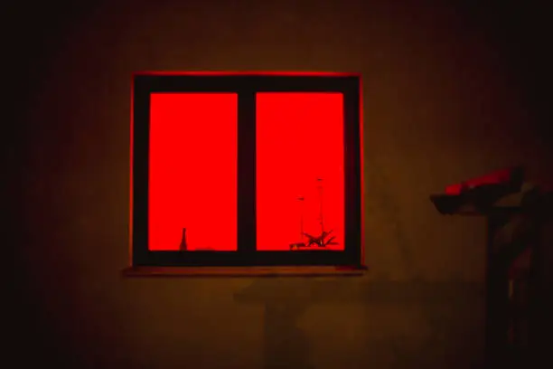 Photo of red light from the window. the red window shines mystically at night.
