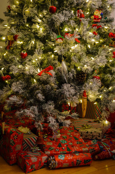 istock Decorated green & white Christmas tree with wrapped presents underneath 1292777278