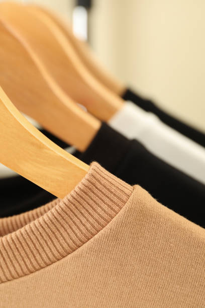 istock Hangers with stylish sweatshirts, close up and space for text 1292777299