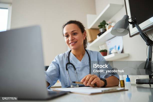 Doctor Clicking On A Laptop Before Her Stock Photo - Download Image Now - Doctor, Healthcare And Medicine, Computer