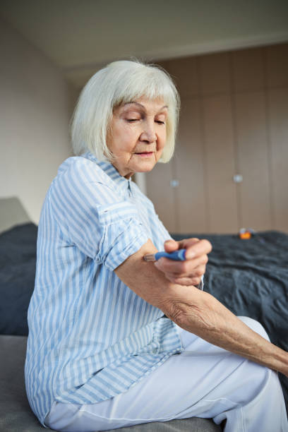 istock Dissatisfied aging lady using a medical autoinjector 1292778193