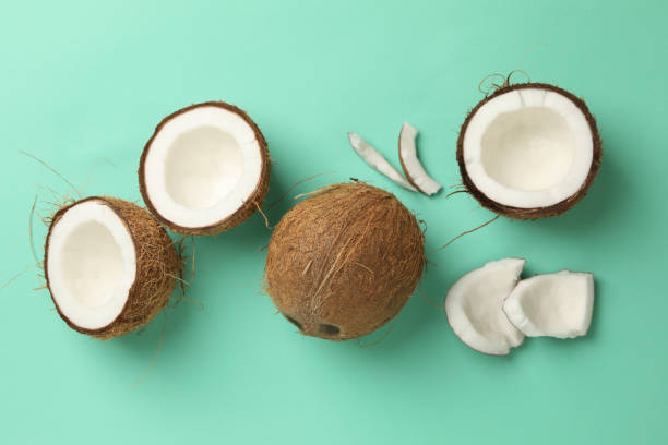istock Fresh tasty coconut on mint background, top view 1292778590