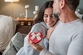 Romantic couple at home. Men giving a present to his girlfriend