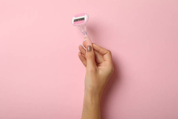 istock Female hand hold razor on pink background, space for text 1292779910