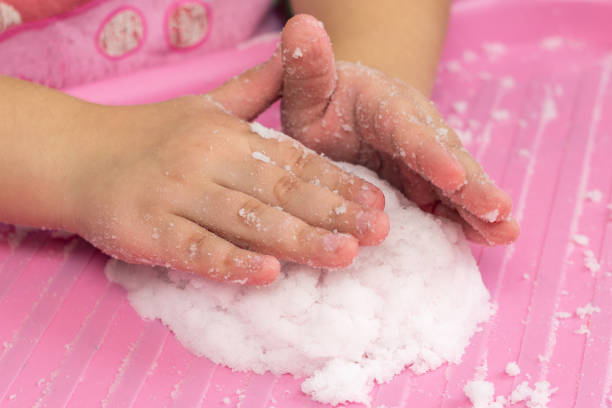 Child plays with artificial snow for home decoration Child plays with artificial snow for home decoration. fake snow stock pictures, royalty-free photos & images