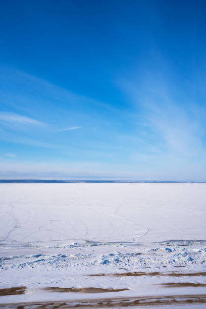 istock Top view of a frozen river with visible paths on a cold winter day with blue sky 1292782285