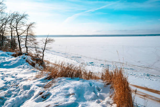 istock Top view of a frozen river with visible paths on a cold winter day with blue sky 1292782830