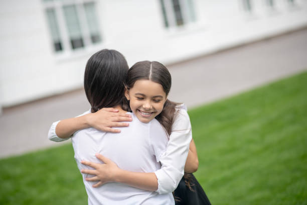 istock Daughter hugging tightly mom in the schoolyard 1292782926