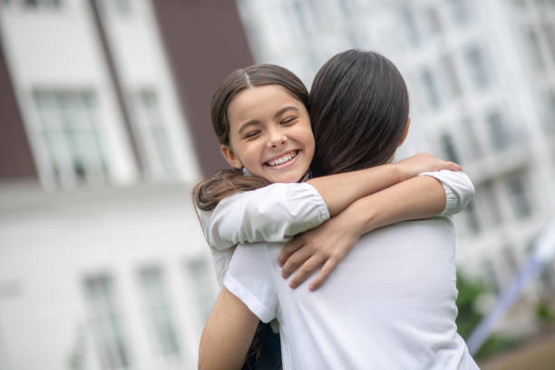 istock Mom with her back to camera hugging daughter 1292782934